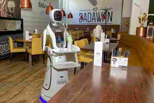 Robot waiters serve drinks and take temperatures at this Dutch restaurant
